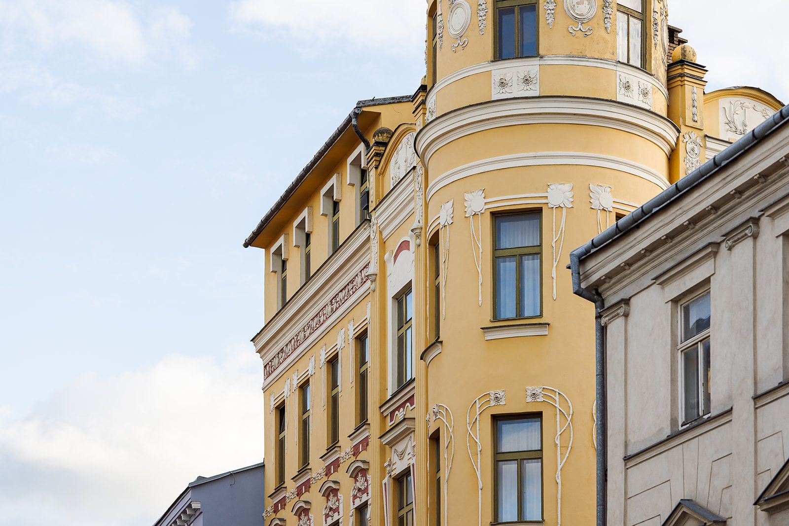 Un edificio de varios pisos con detalles arquitectónicos clásicos, incluyendo cornices ornamentados y molduras decorativas.