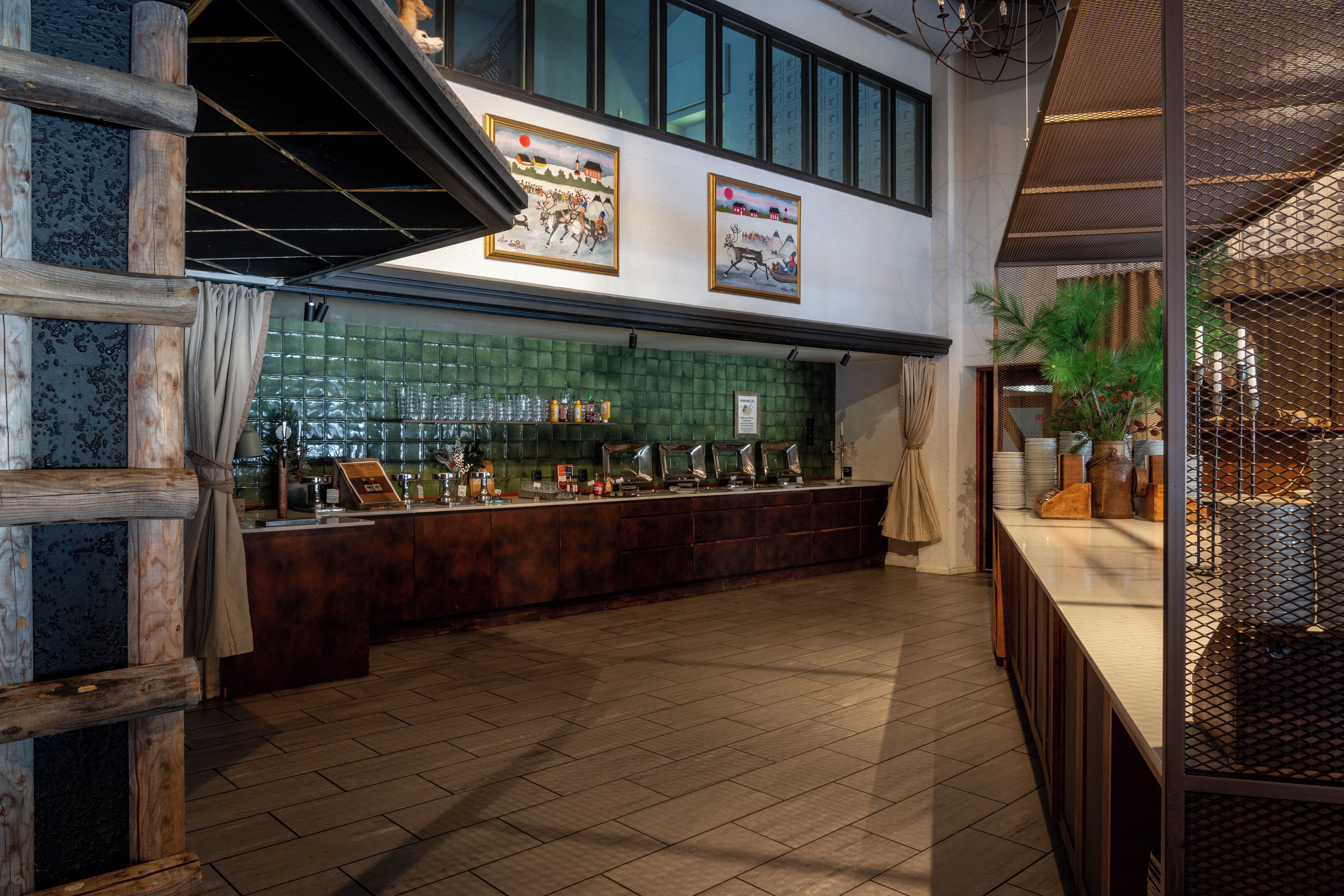 Zona de bar con mostrador, estanterías con botellas y pared revestida de azulejos verdes.