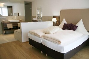 A hotel room with a bed, bedside table, lamp, and a bathroom with a sink and mirror. - Landgasthof Hotel Vilserwirt (Altfraunhofen)