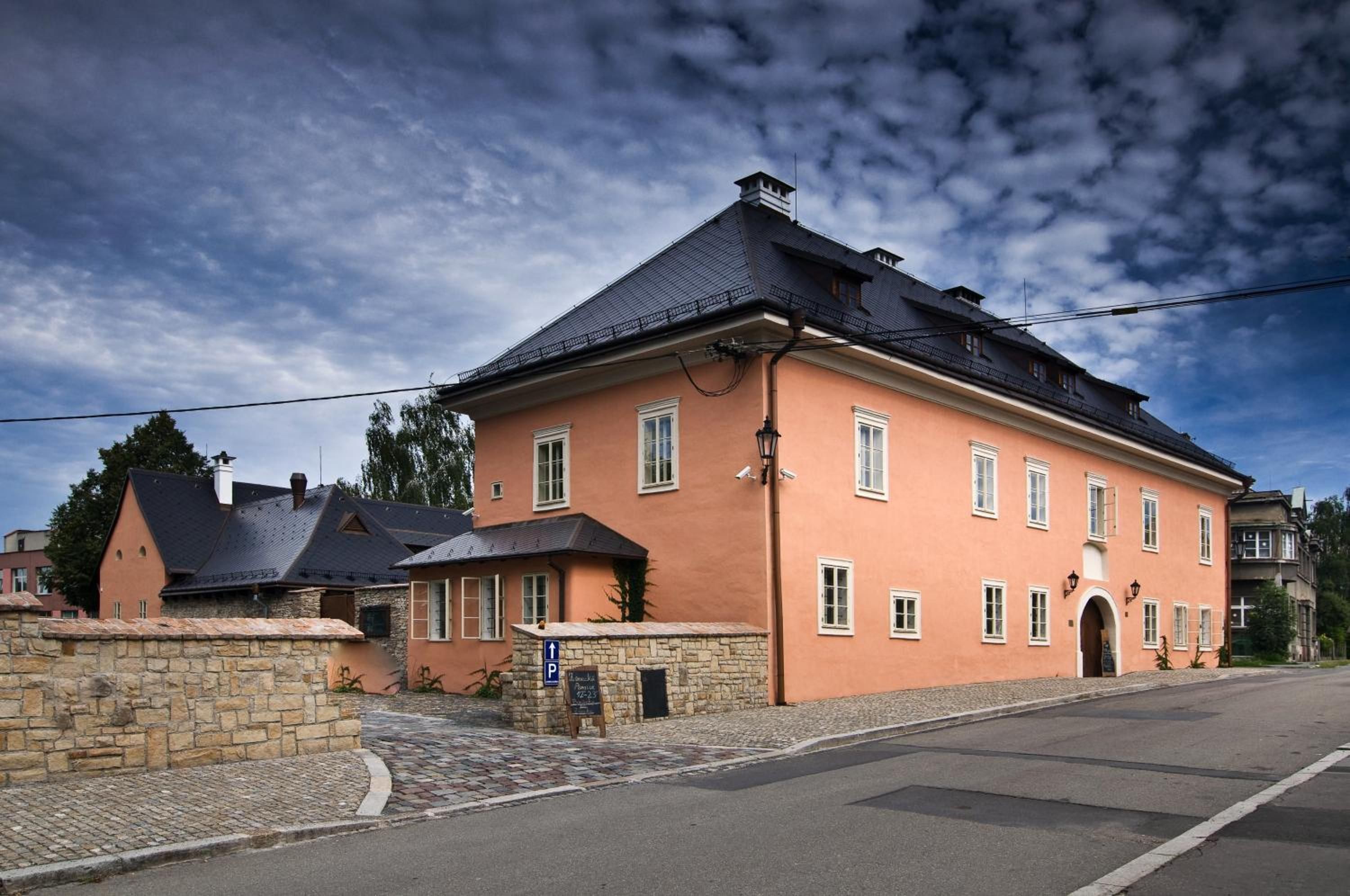 A large, two-story building with a stone facade and a dark roof.