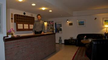 A reception area with a brick counter, a couch, and a lamp.