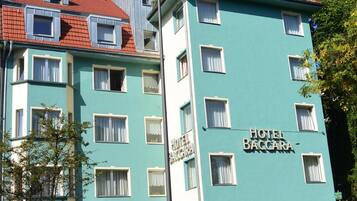 Een gebouw met twee verdiepingen waarop het bord 'HOTEL BACCARA' staat.