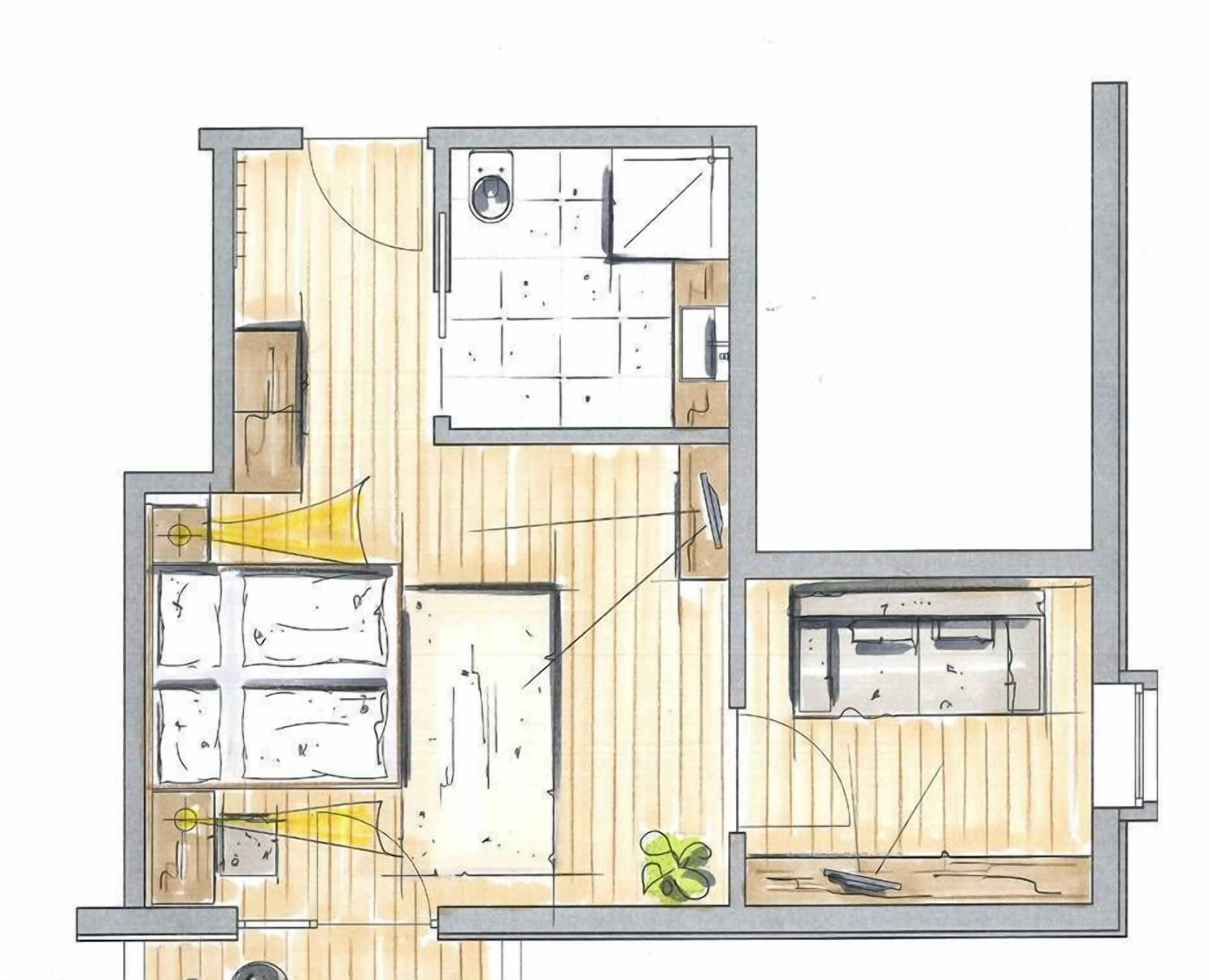 Un plan d’étage d’une chambre d’hôtel comprenant une salle de bain, un coin cuisine et un espace salon.
