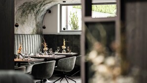 Un espace de restauration moderne avec un mur incurvé, des sièges en forme de banc et une vue sur la verdure à l’extérieur.