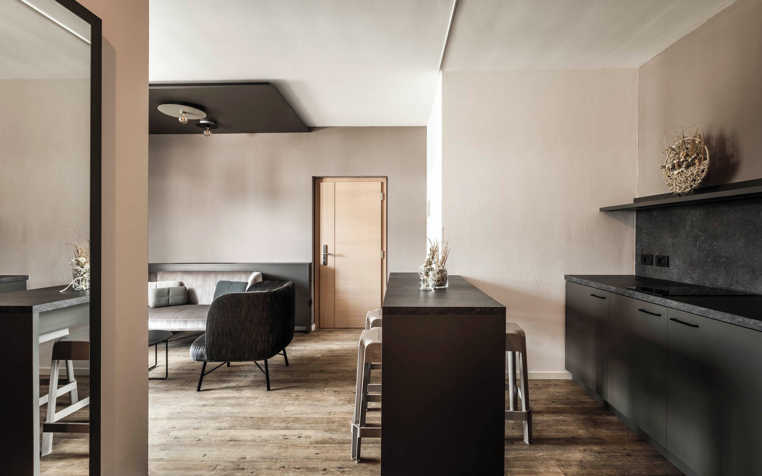 Una cocina moderna con armarios oscuros y suelo de madera.