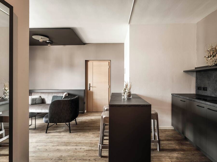 Una cocina moderna con armarios oscuros y suelo de madera.