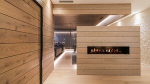 Un intérieur moderne avec des murs lambrés, une cheminée et un couloir bien éclairé.