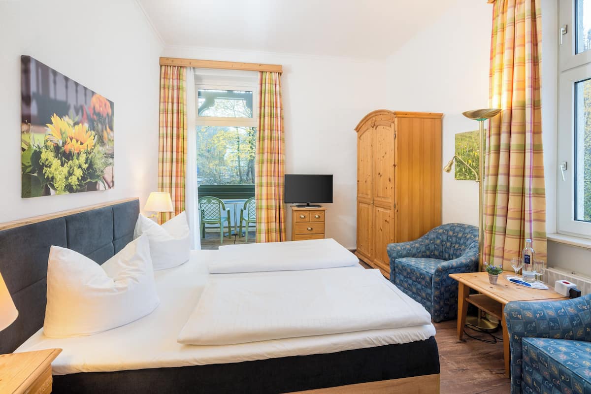 Une chambre d’hôtel comprenant un lit, un bureau, une chaise, une armoire et un téléviseur.