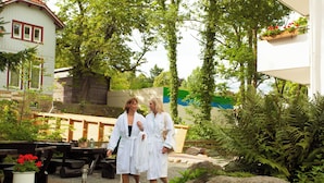 Un espace jardin aménagé avec des bancs en bois et des plantes en pot.