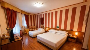 A hotel room with two beds, a desk, a chair, a TV, and a mirror. - Phi Hotel Pianfei (Pianfei)