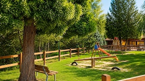 A playground with a seesaw, a slide, and a swing set.