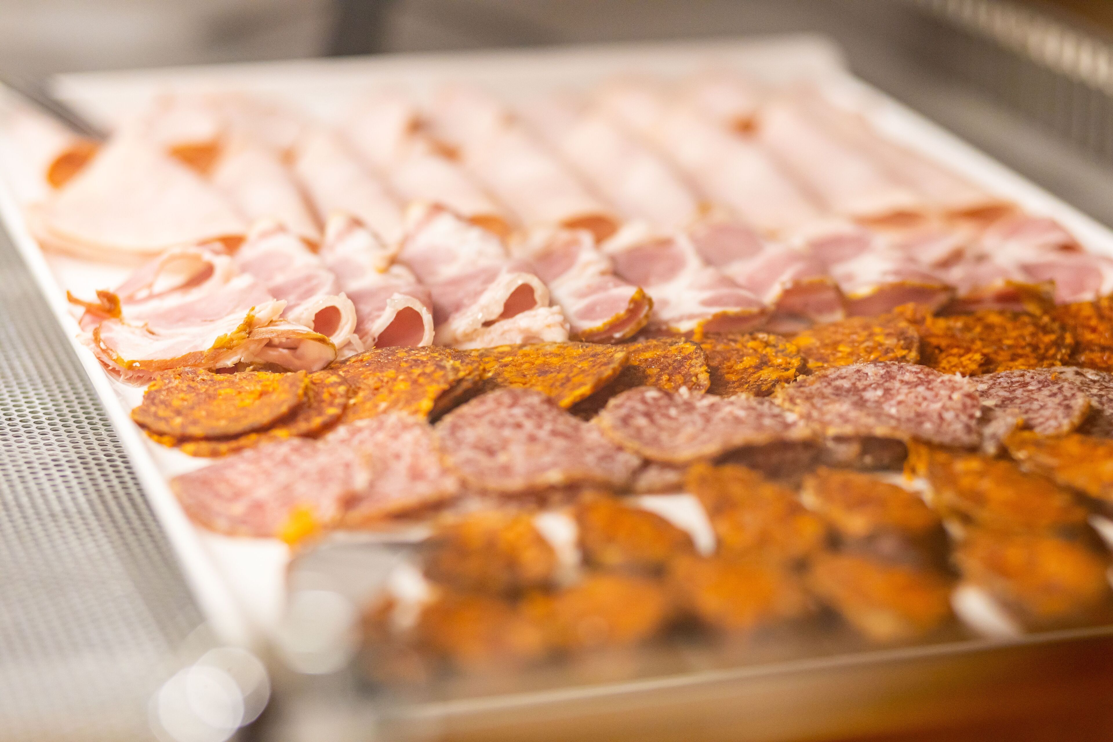 A variety of sliced meats on a tray.
