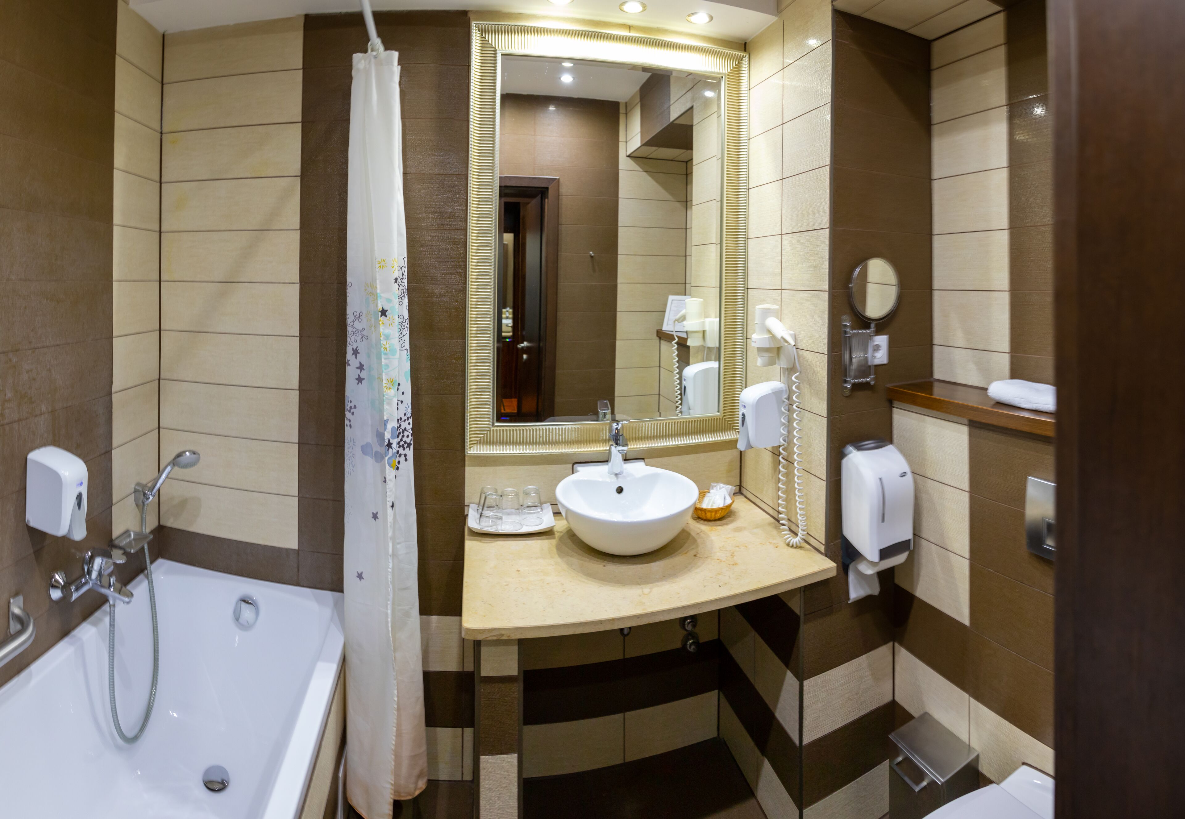 Un baño moderno con bañera, lavamanos, espejo y ducha.