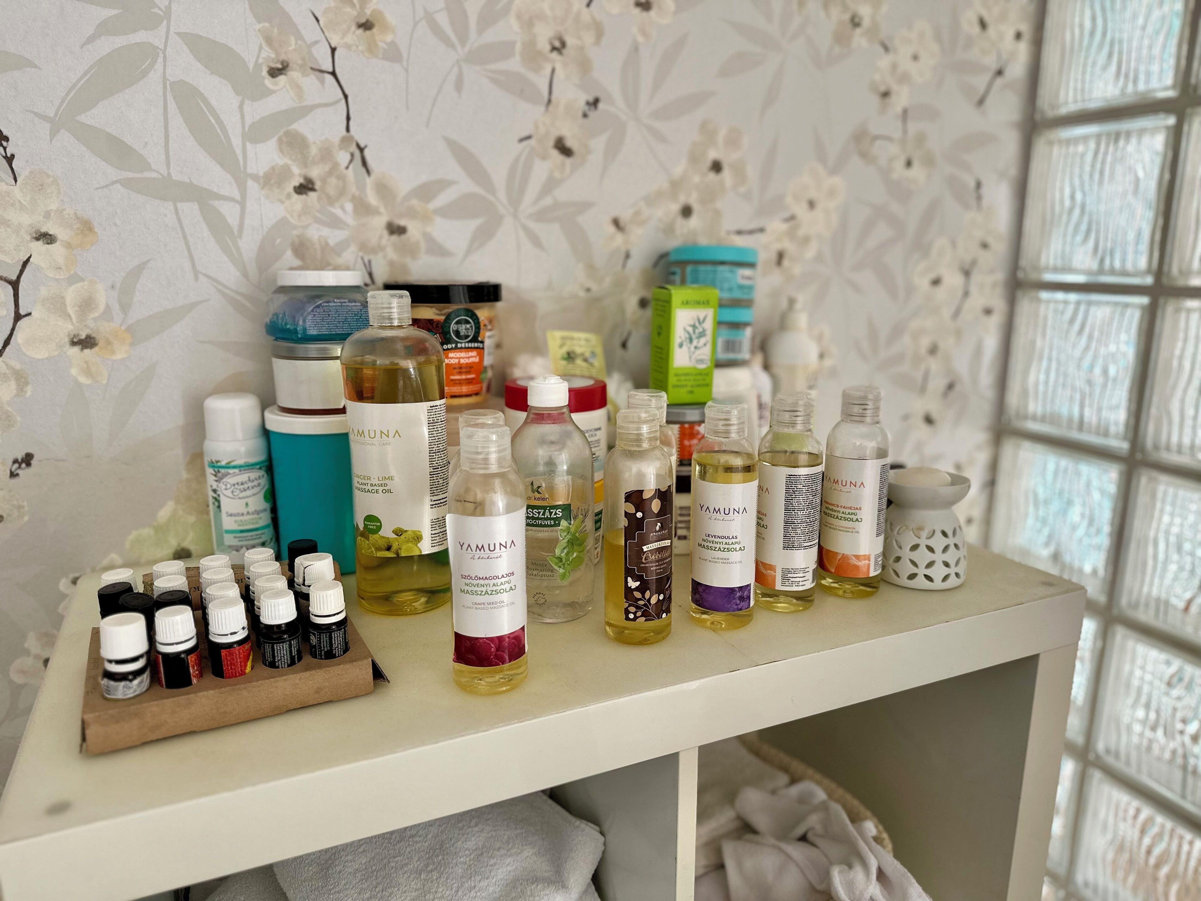 A shelf with various bottles of essential oils and skincare products.