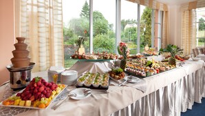 Una mesa de buffet con diferentes alimentos y una cafetera.