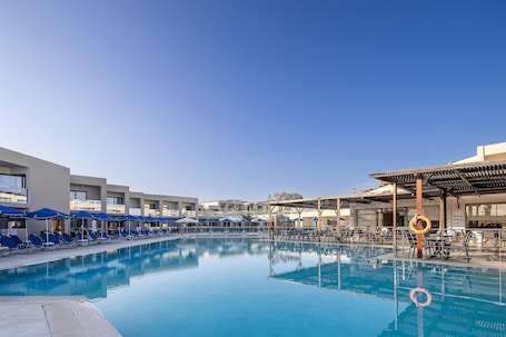 Una piscina al aire libre de temporada, sillones reclinables de piscina