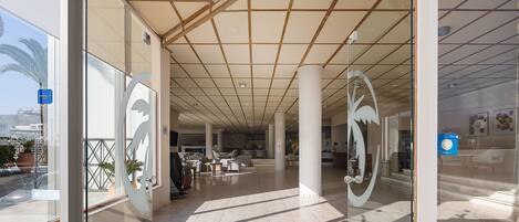 Un vestíbulo amplio con techo alto, grandes columnas y diseño moderno.