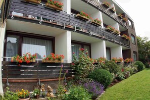 A multi-story building with balconies adorned with flower boxes.