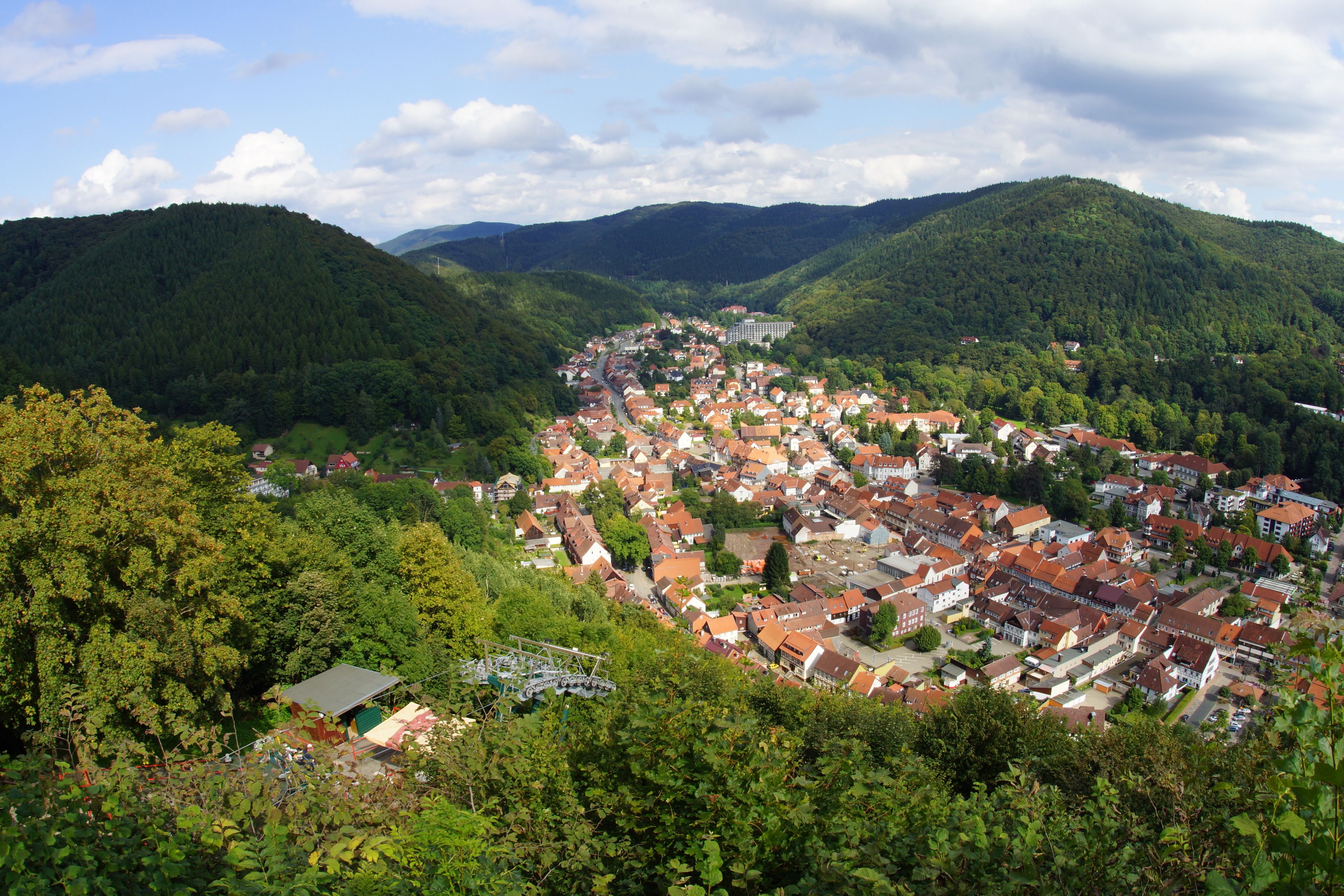 A town nestled in a valley surrounded by hills, featuring a mix of residential buildings and greenery.