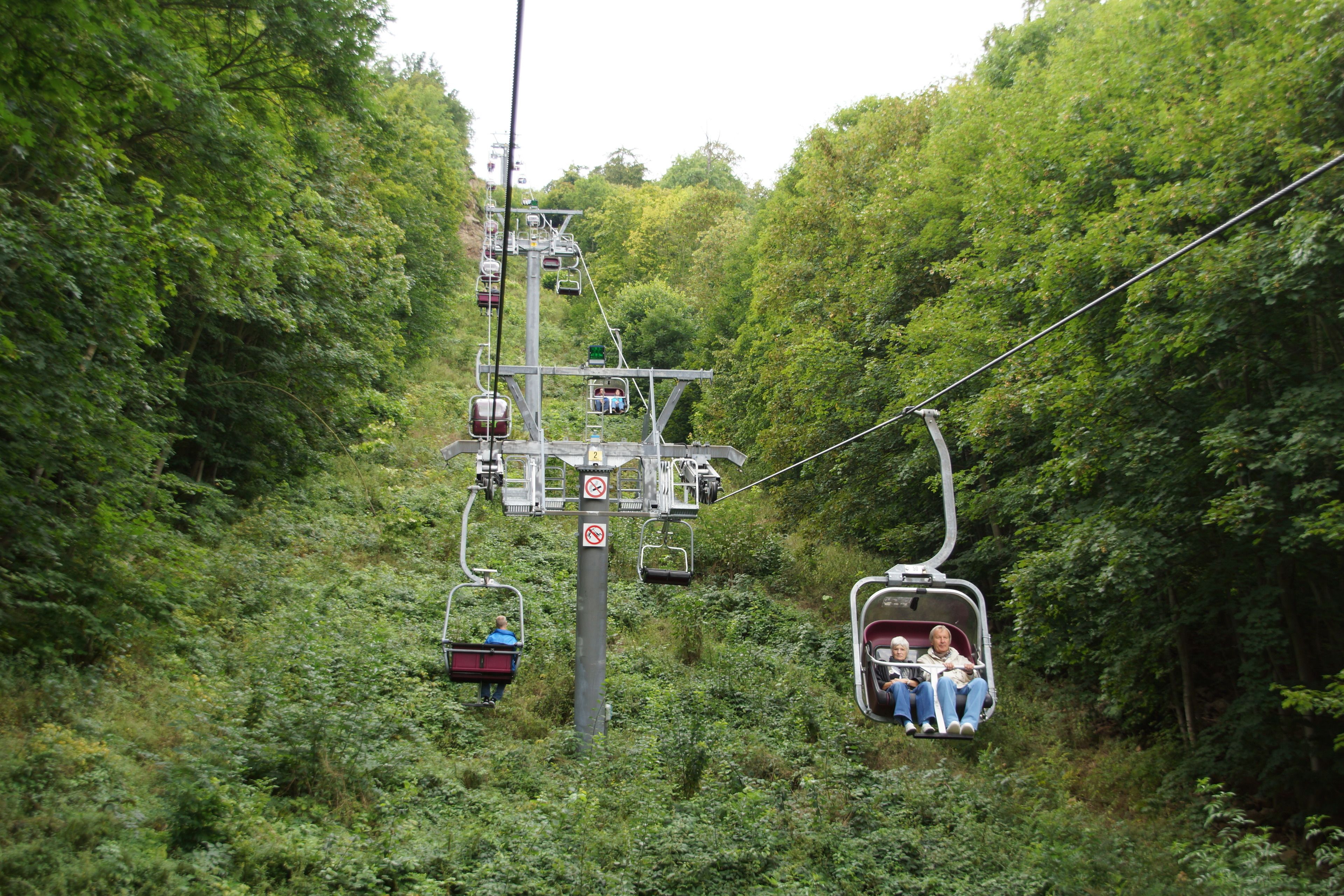 A cable car system in a forested area with passengers.