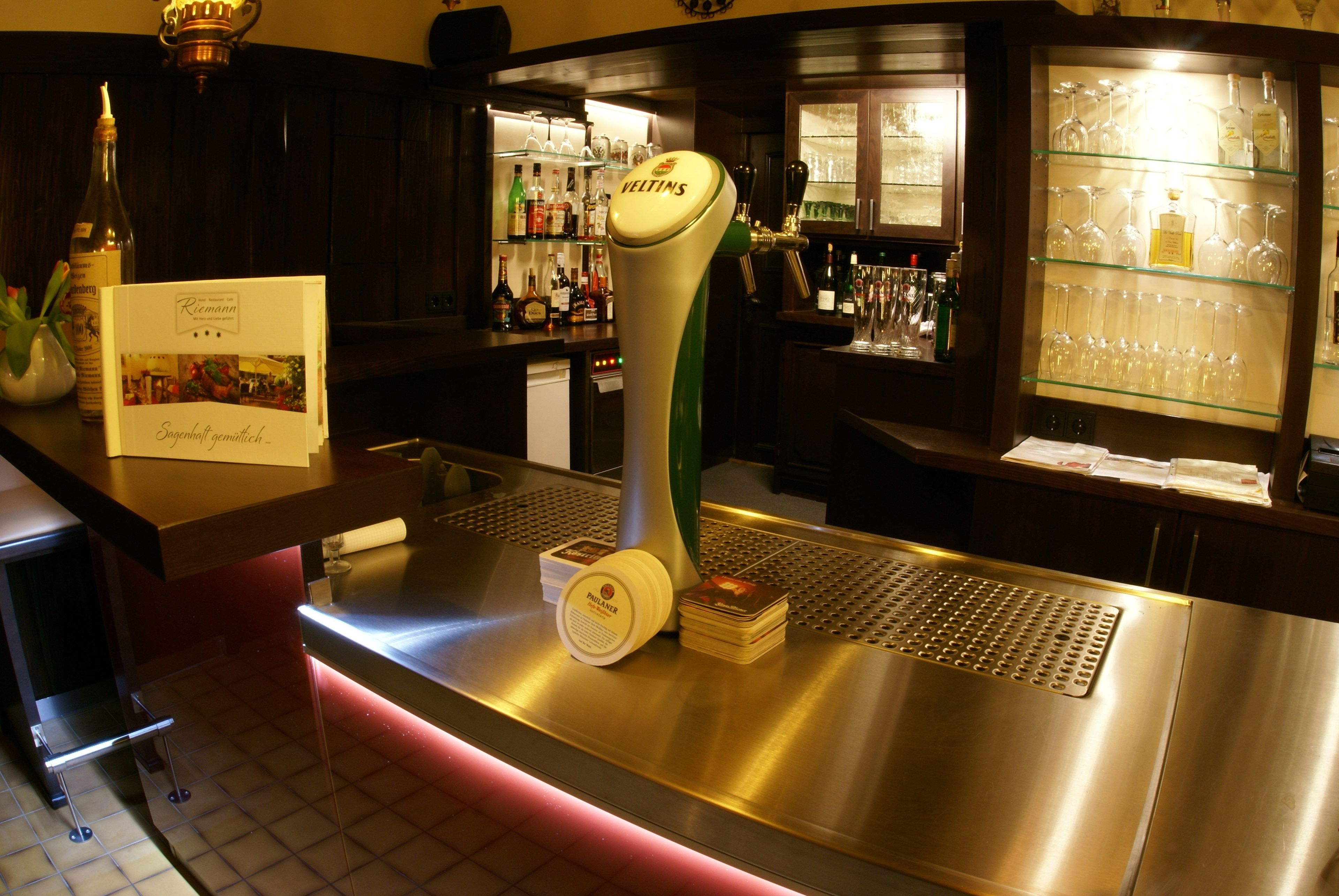 Una zona de bar con una grifería de cerveza, una botella de vino y un menú.