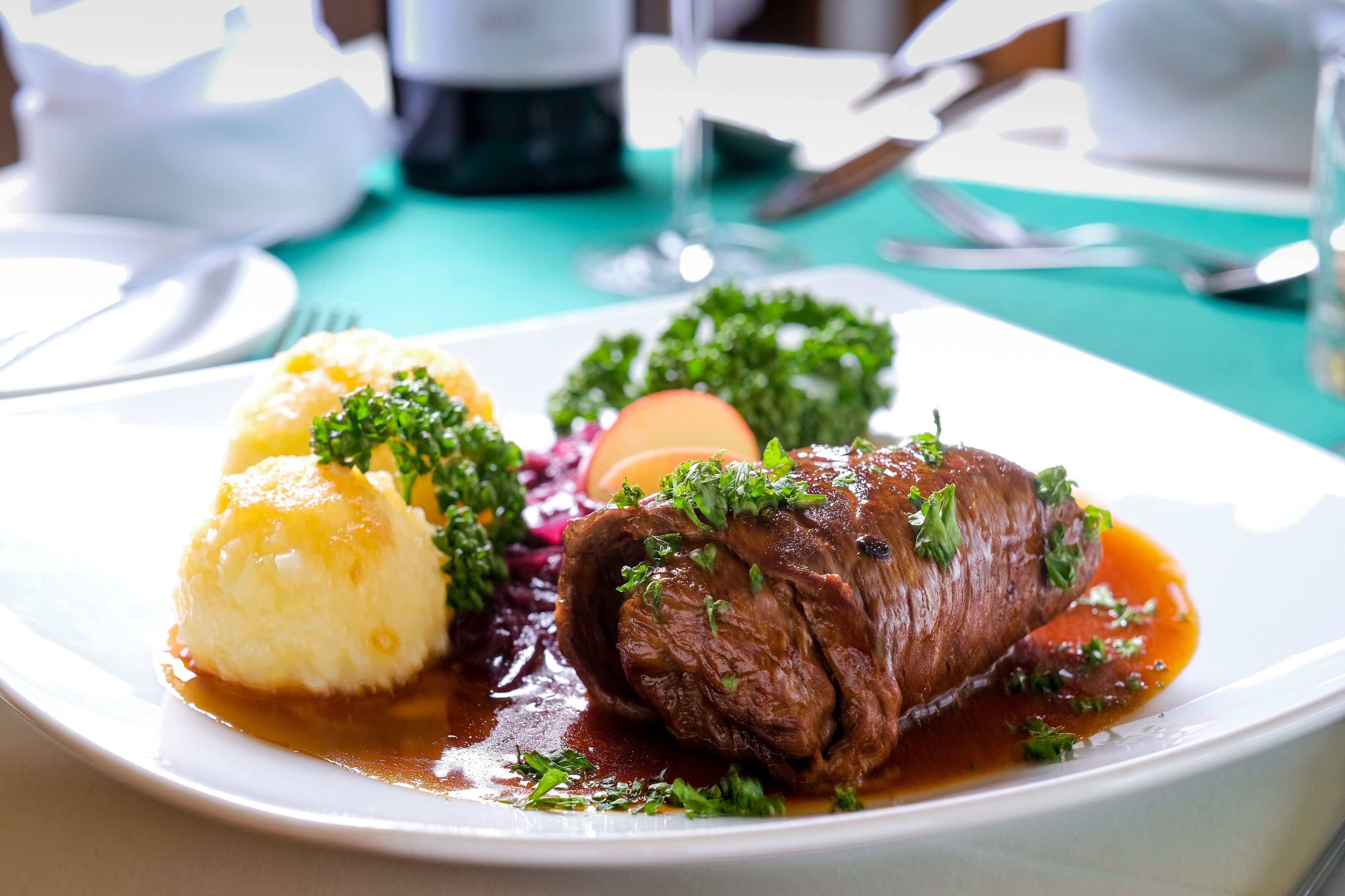Ein Teller mit Rindfleischsteak, Kartoffelpüree und Rotkohl.