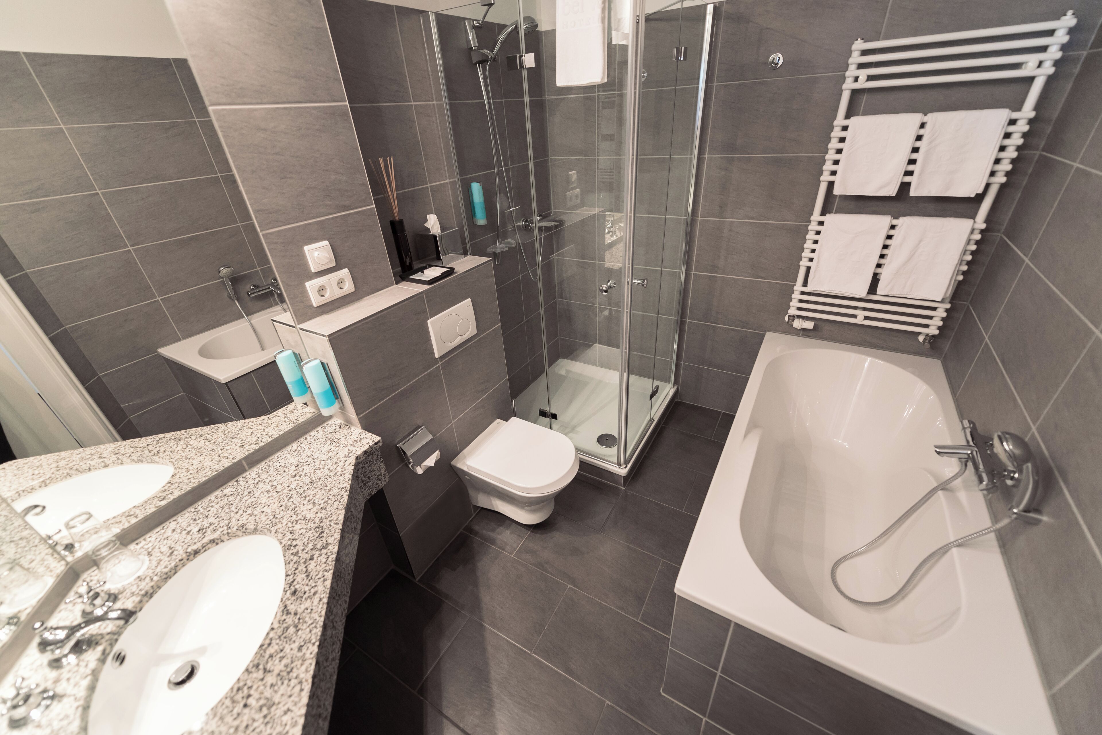 Un baño moderno con ducha de vidrio, bañera independiente y lavamanos con encimera.