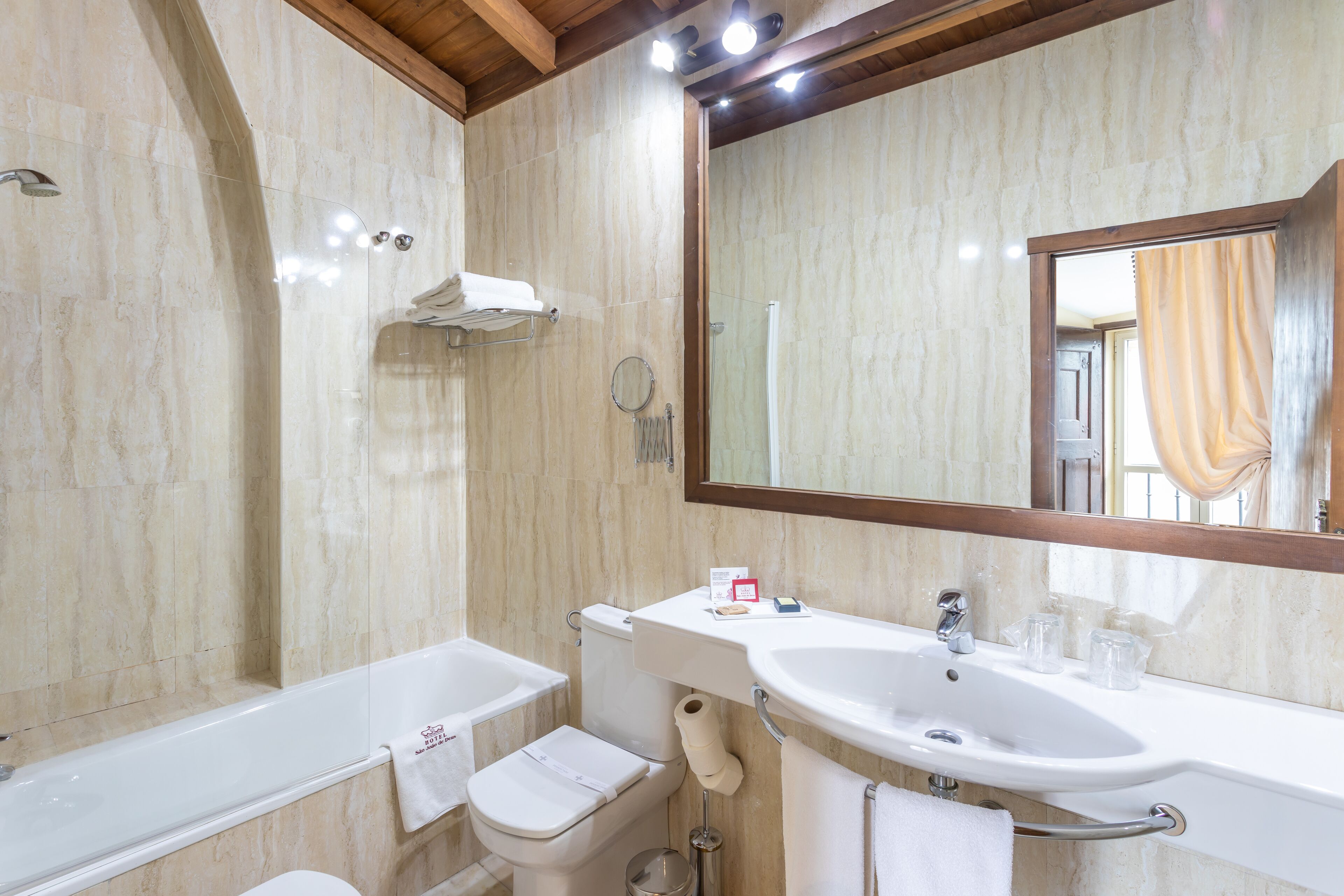 A bathroom with a bathtub, toilet, sink, and mirror.