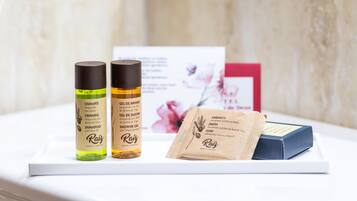 Presentación de tres productos para el cuidado del cabello y una pastilla de jabón sobre una superficie blanca.