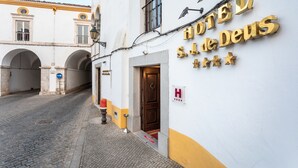 Entrada d'un hotel amb un rètol que diu "HOTEL S.J. de Deus" i un senyal blau de direcció.