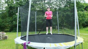 Un trampolín en un entorno exterior con una malla de protección.