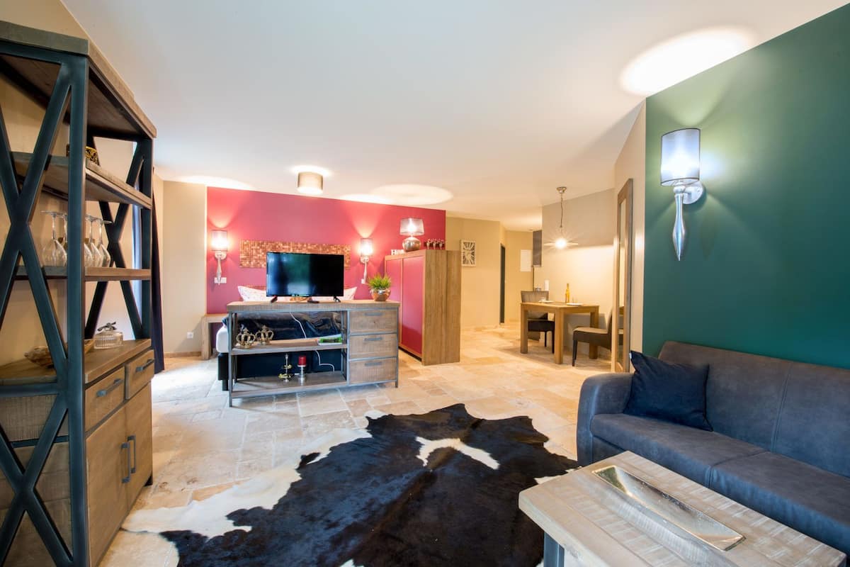 Un salon moderne comprenant un canapé, un téléviseur, un meuble en bois et un coin repas.