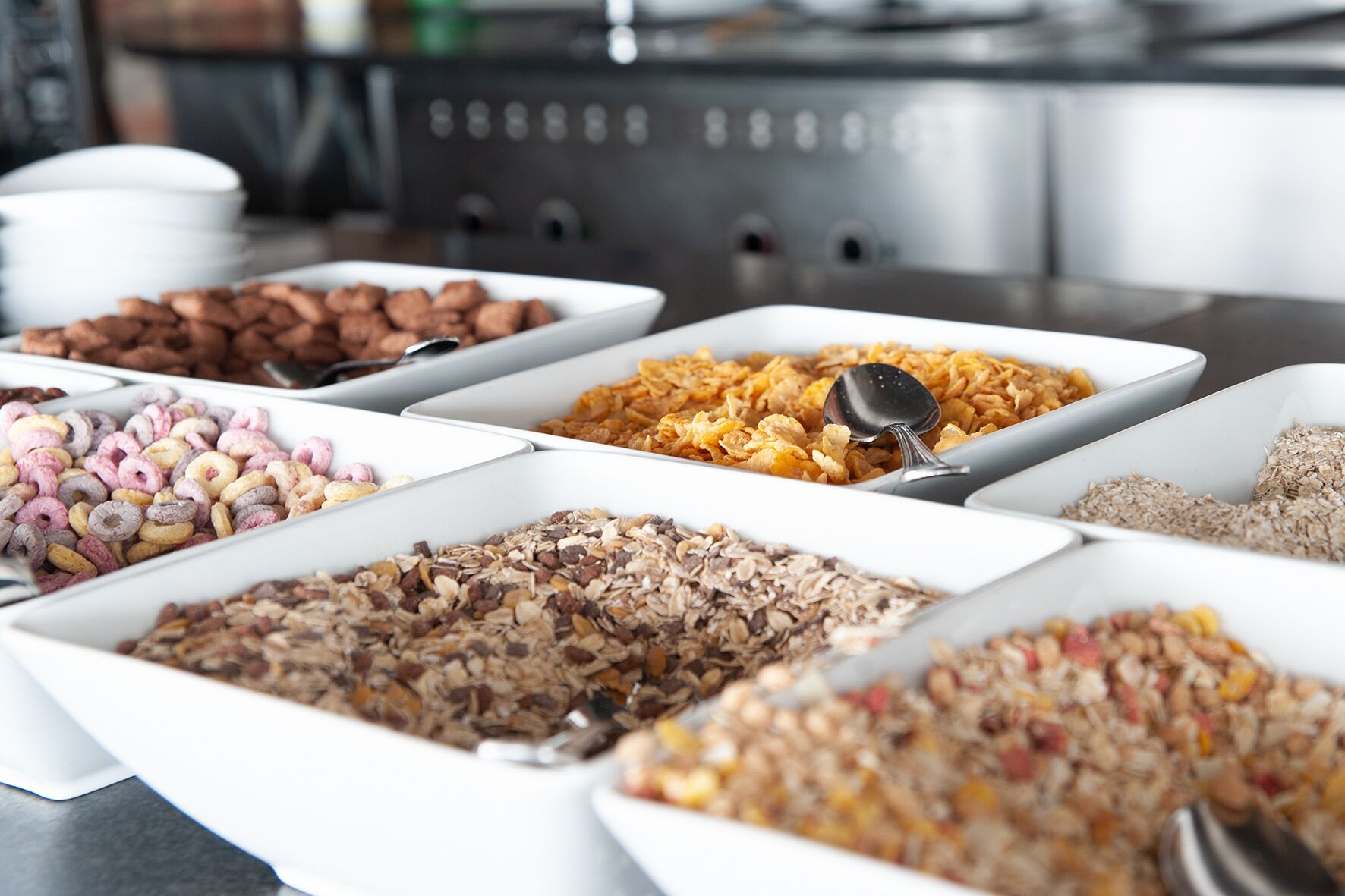 A buffet with various food options including cereals, nuts, and dried fruits.
