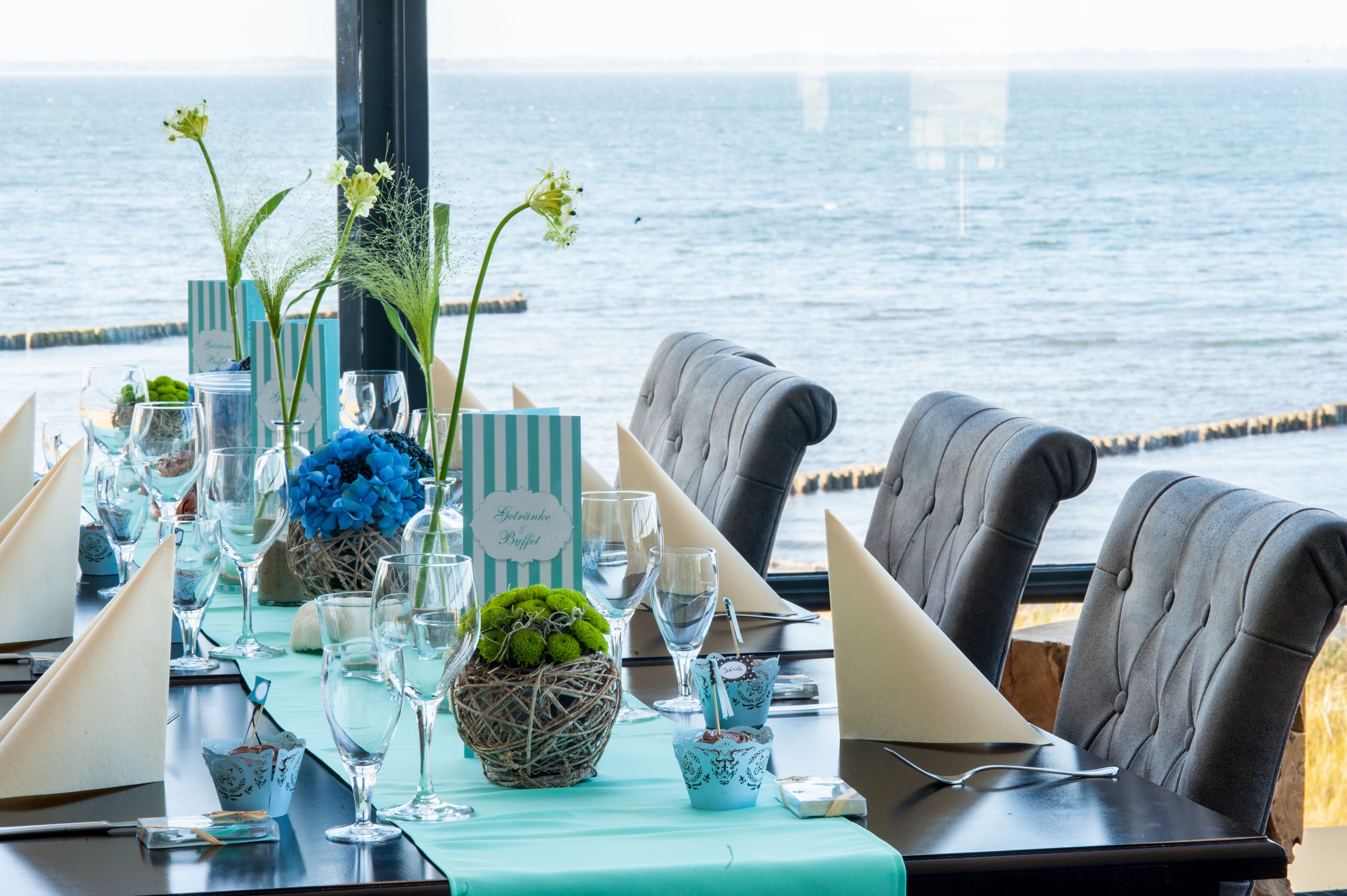 A table set for a meal with a view of the sea.