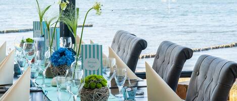 A table set for a meal with a view of the sea.