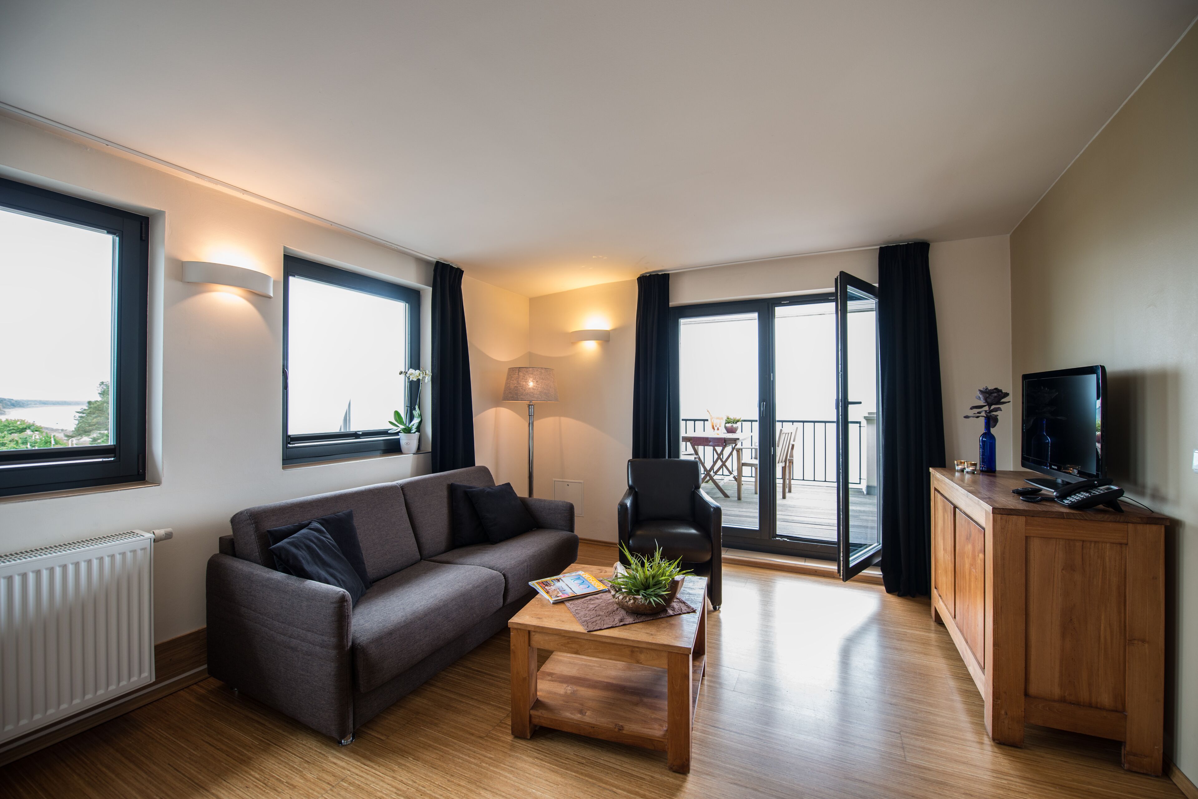 Un salon moderne avec un canapé, une table basse et un téléviseur.
