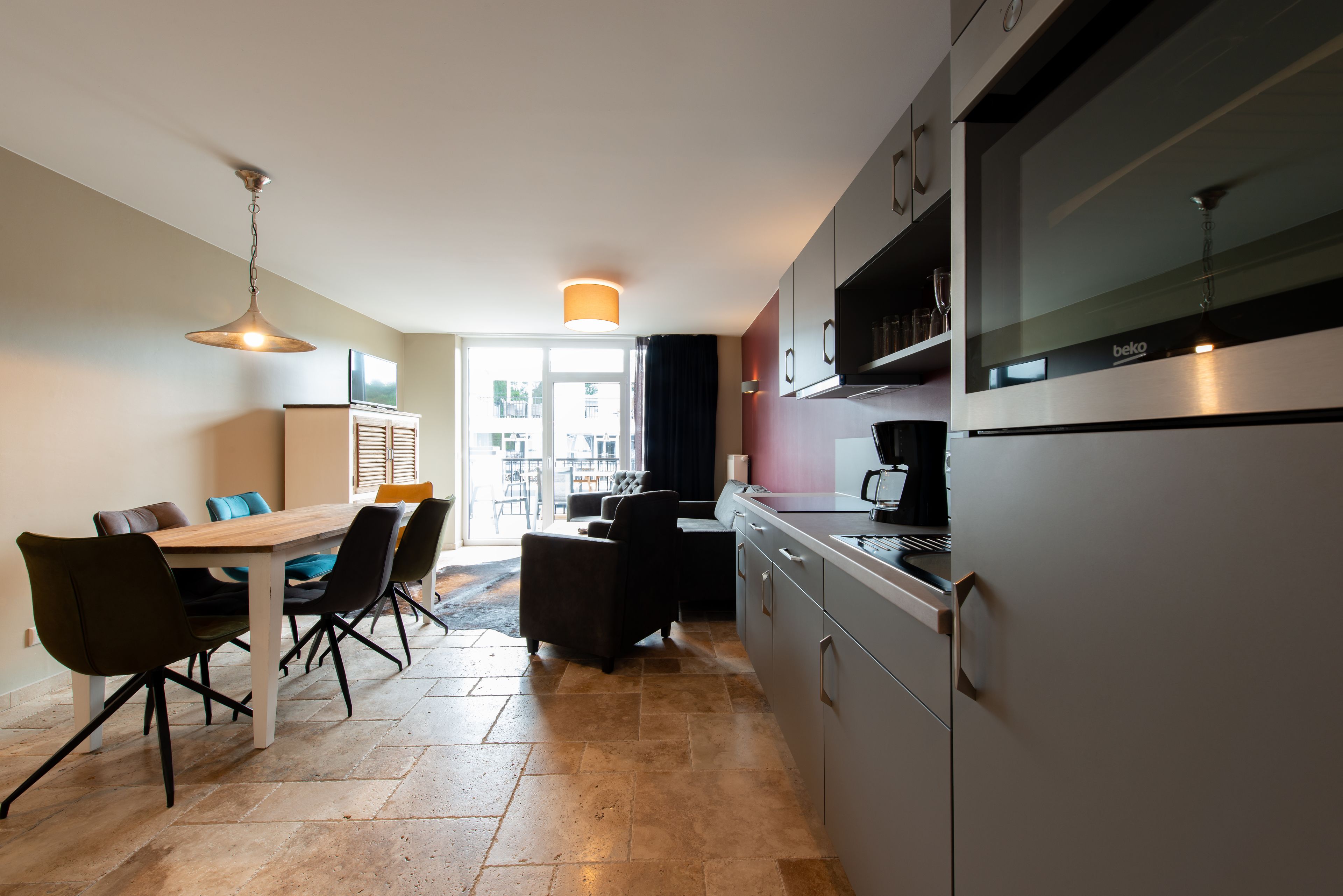Une cuisine moderne avec un coin repas, comprenant une grande table, des chaises et un réfrigérateur.