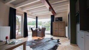Un amplio salón con una mesa de comedor, un rug de cuero y vistas al exterior.