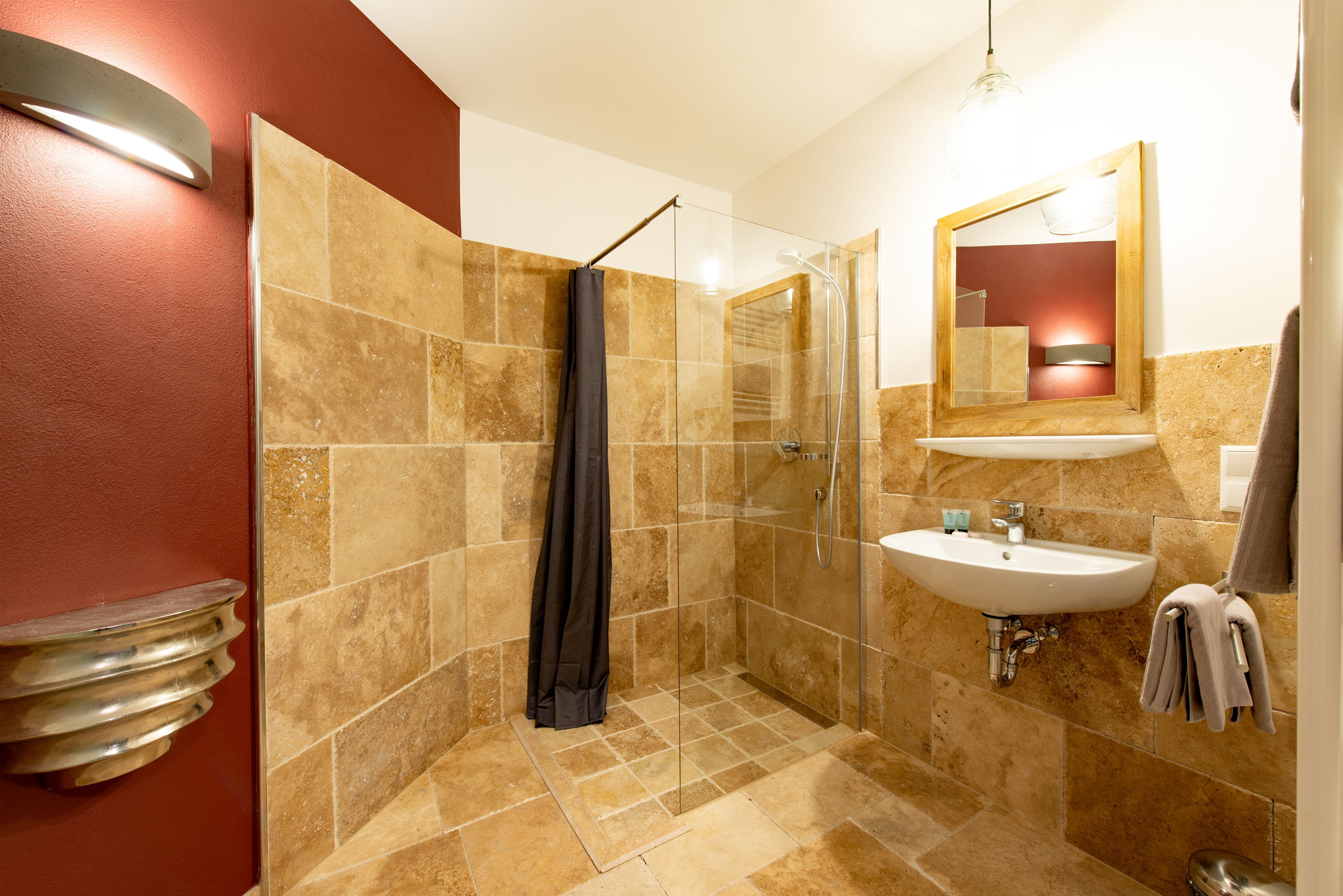 Ein modernes Badezimmer mit einer begehbaren Glasdusche, einem Waschbecken und einem Spiegel.