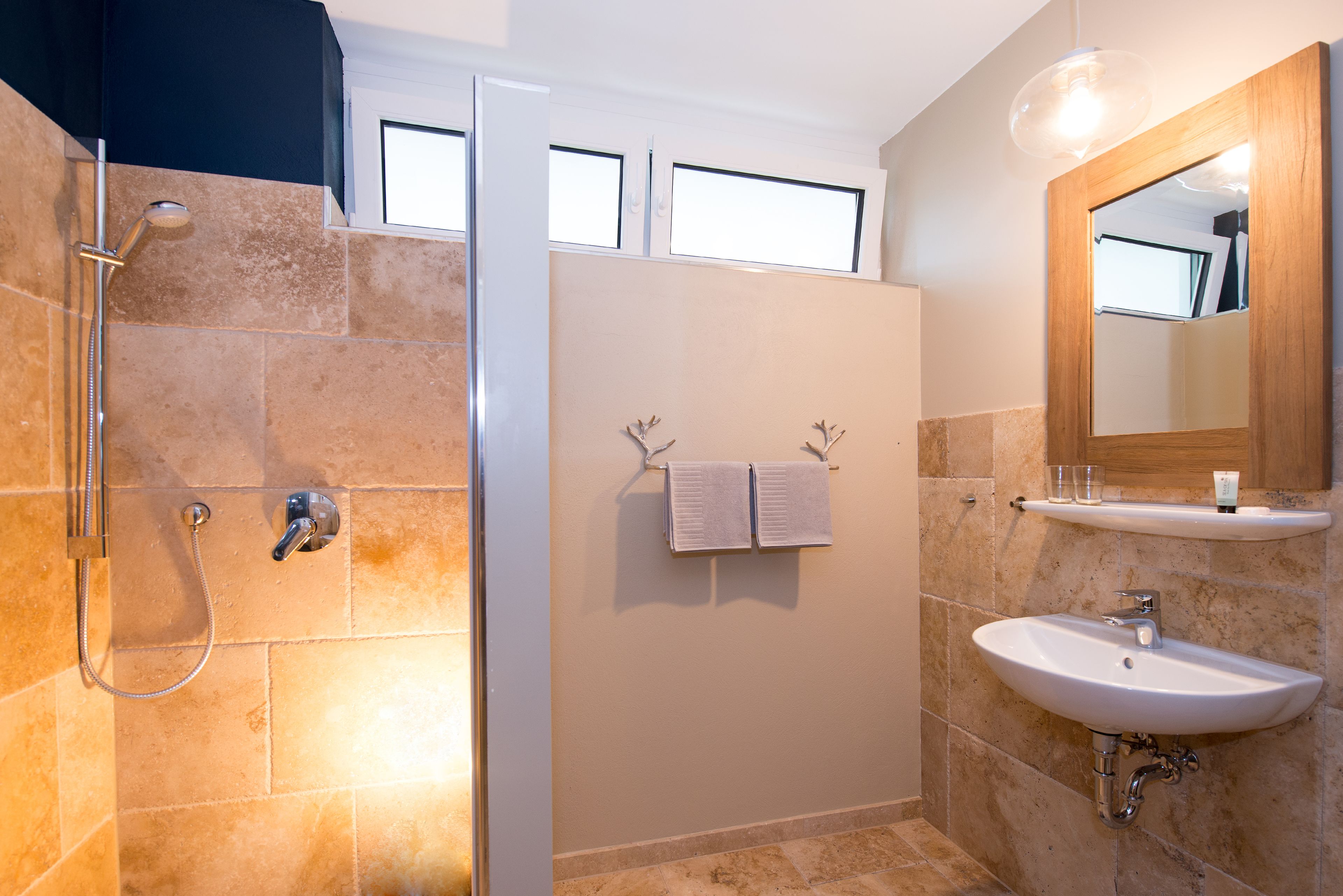 A bathroom with a shower, a sink, and a mirror.