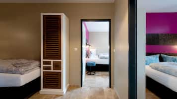 Une chambre à coucher avec un lit, une armoire et une salle de bain visible à travers une porte ouverte.