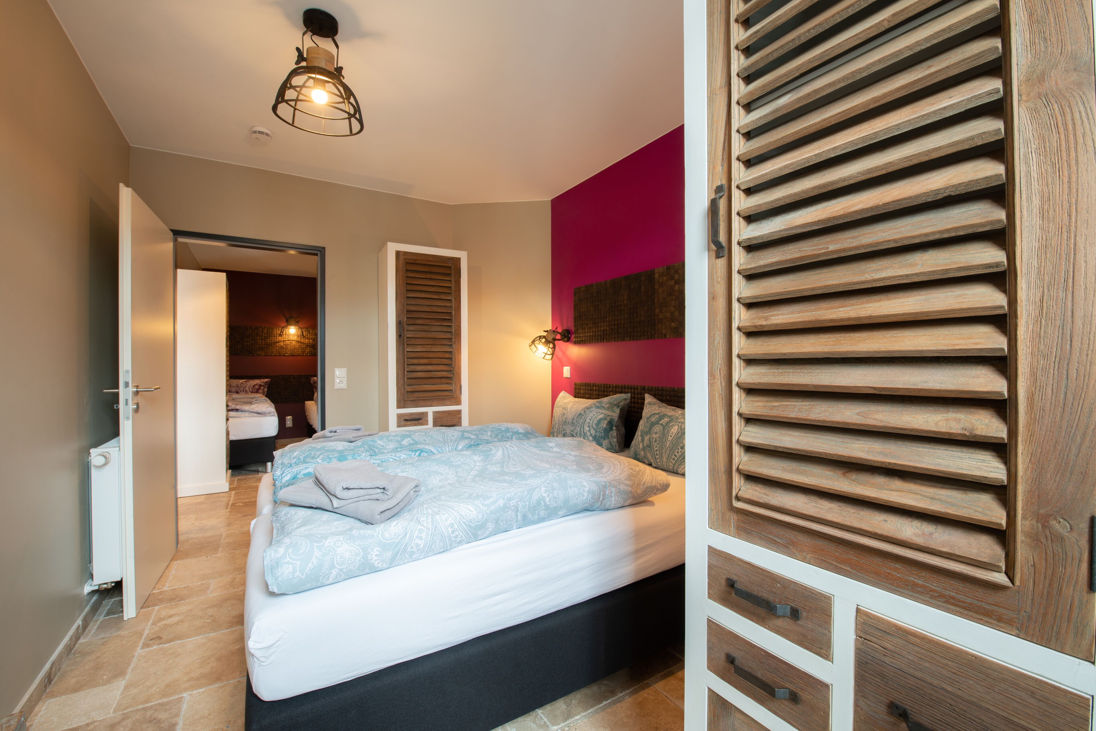 Une chambre à coucher comprenant un lit, une armoire et une porte donnant sur une salle de bain.