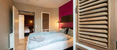 Una camera da letto con un letto, un armadio e una porta che dà su un bagno.