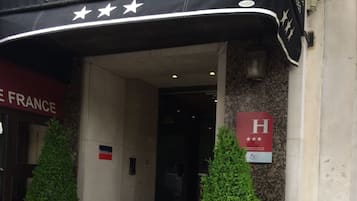 The entrance to Hotel De France Invalides with a sign indicating a 4-star rating.