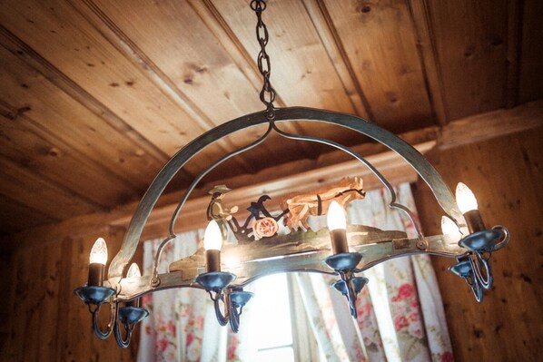 A chandelier with six lights and a decorative figure.