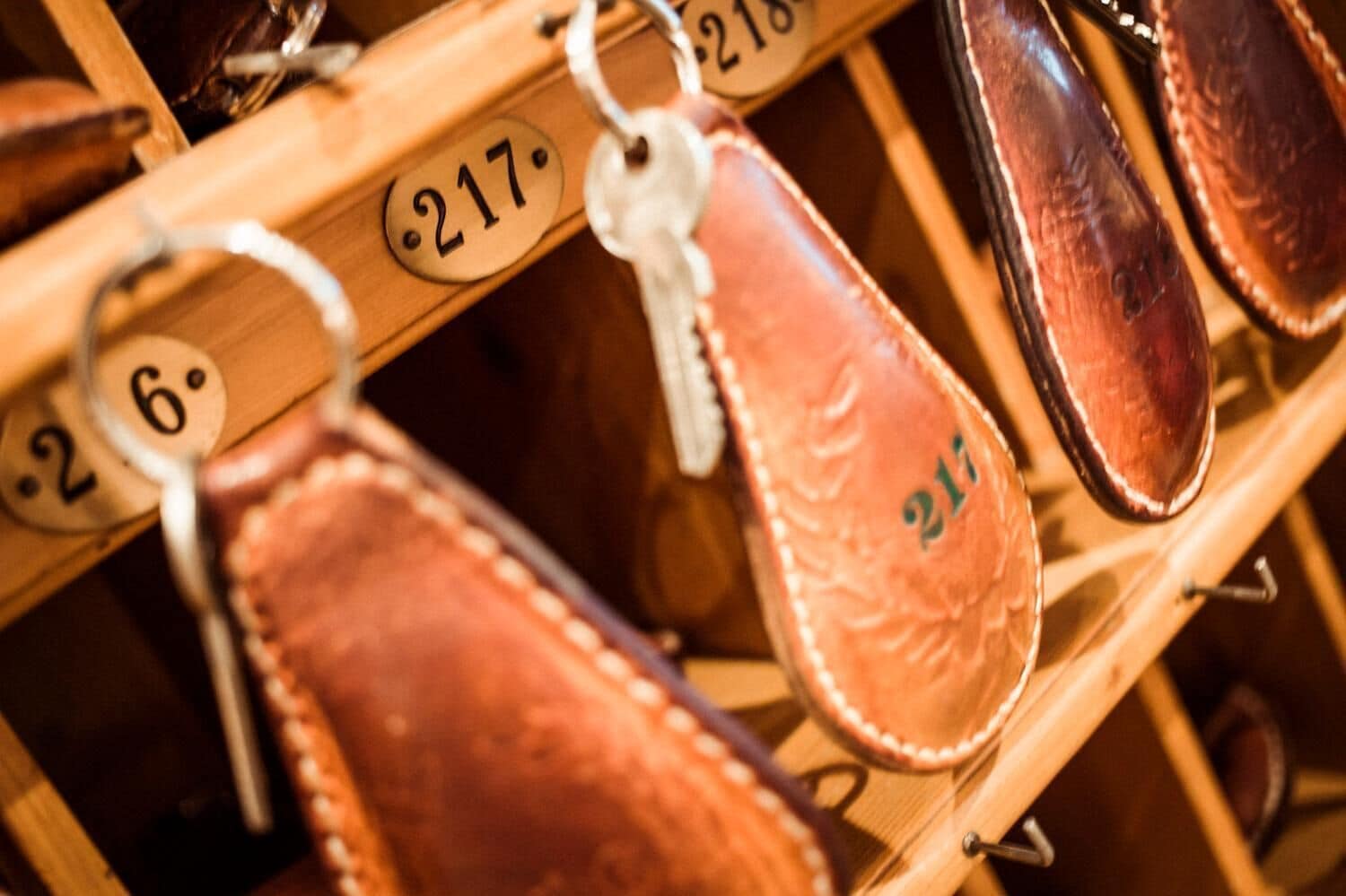 A wooden shoe rack with numbered compartments, each holding a pair of shoes.