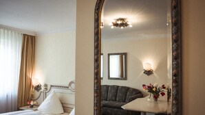 Ein Hotelzimmer mit Bett, Sofa, Tisch und Spiegel.