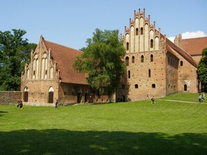 A historic building with a large courtyard and a prominent tower. - Landhotel Felchow (Schwedt/Oder)