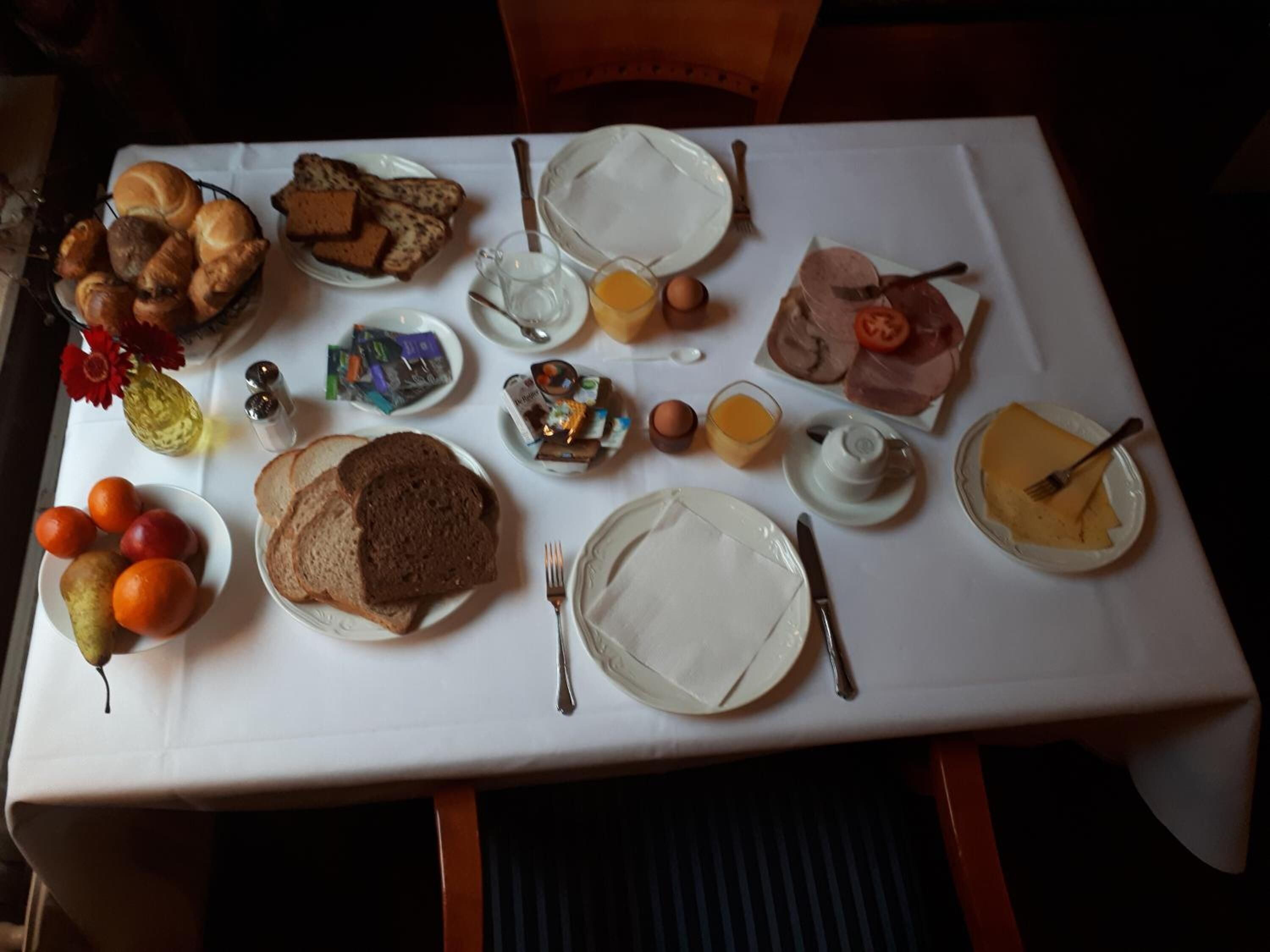 Uma mesa de café da manhã com diversos alimentos e utensílios.