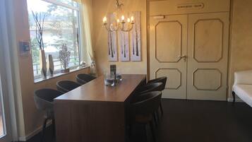 A conference room with a wooden table, chairs, a chandelier, and a door labeled "Konferenzraum".